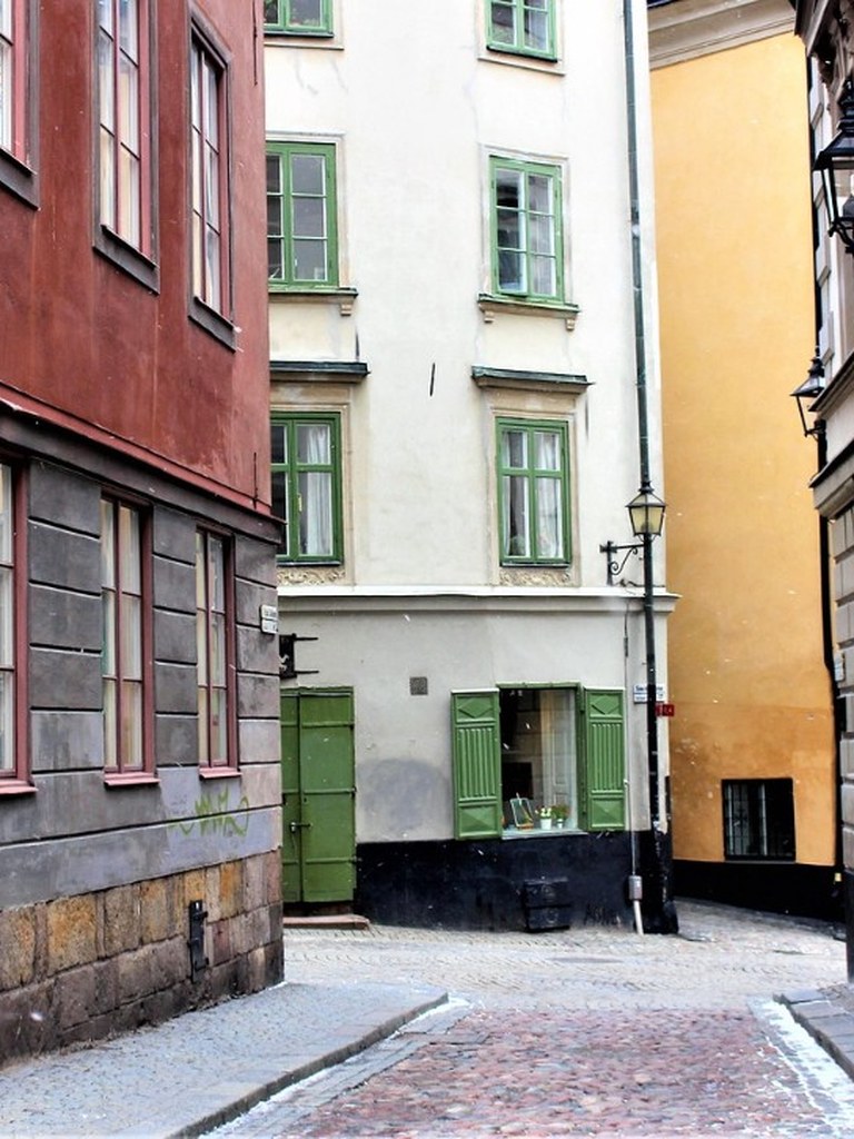 Kullerstensgränd i Gamla Stan med kulörta hus